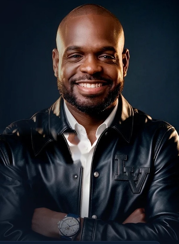 Marvin Sambo smiling, arms crossed, in a black leather jacket